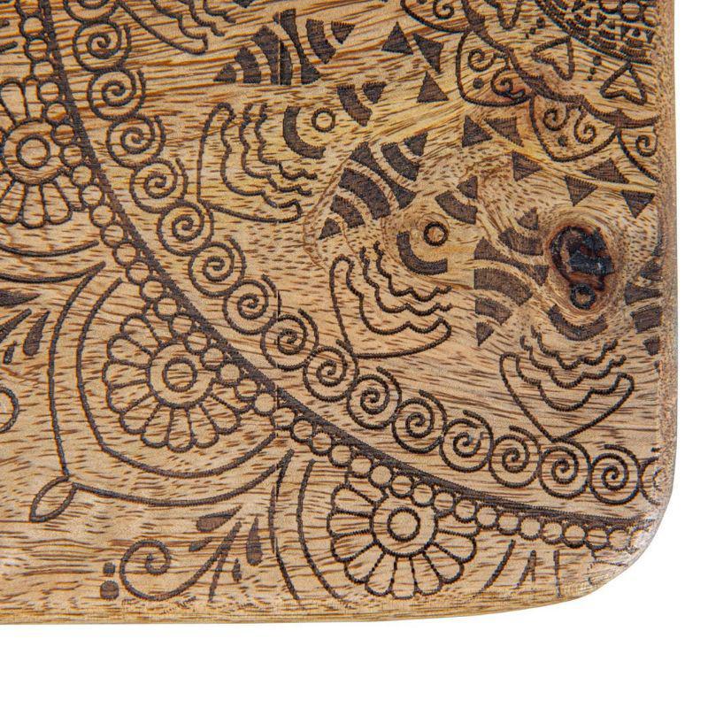 Wooden cutting board with intricate carvings on a white background