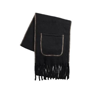 A black knit scarf with fringed ends and a front pocket, featuring light beige contrast stitching along the edges and around the pocket, displayed on a light gray background.