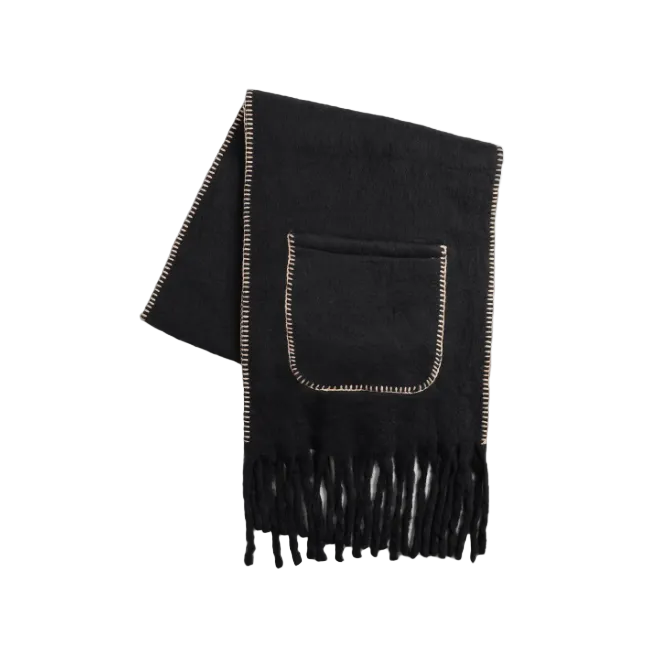 A black knit scarf with fringed ends and a front pocket, featuring light beige contrast stitching along the edges and around the pocket, displayed on a light gray background.