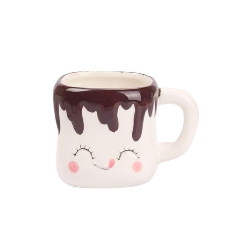 Ceramic mug with a face design and chocolate drizzle on a white background