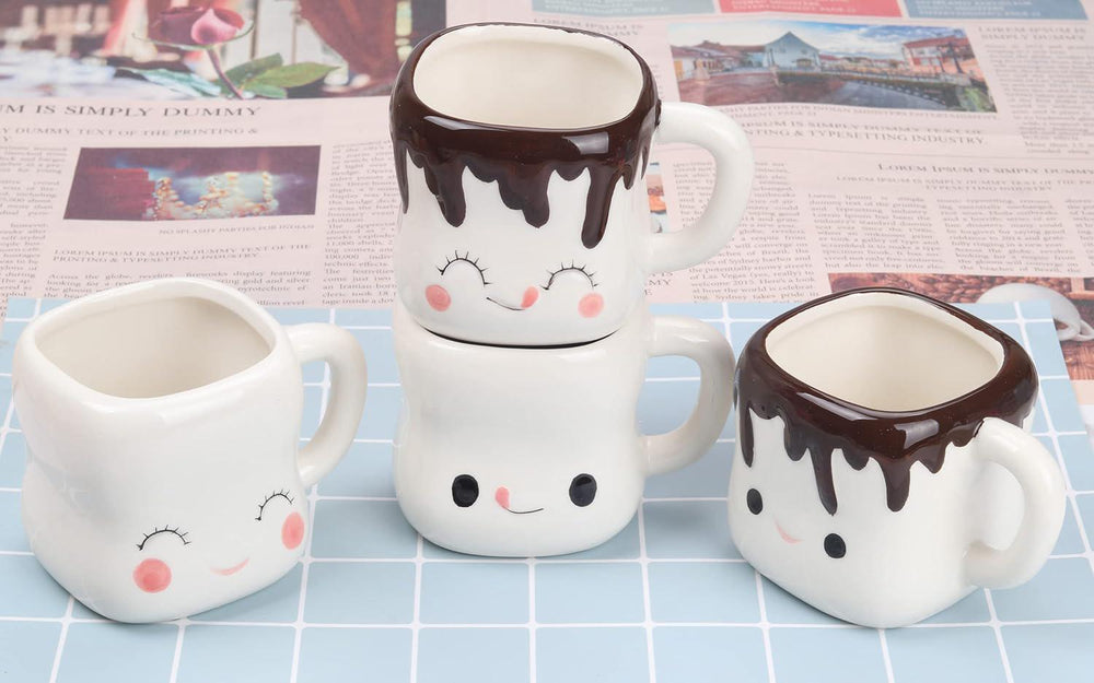 Set of three ceramic mugs with face designs on a checkered surface.