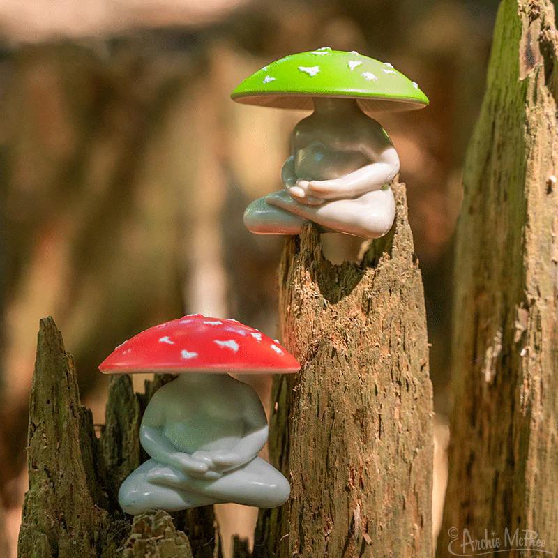 Two garden YOGA figurines with mushroom hats on a wooden background