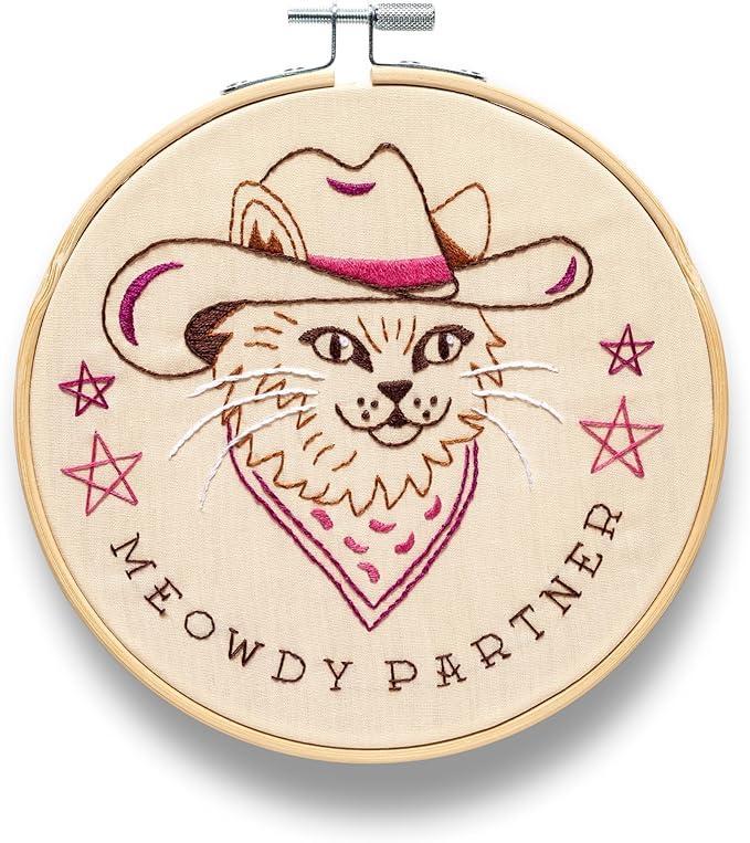 Embroidery hoop with a cat wearing a cowboy hat and bandana, and the text 'Meowy Partner'.