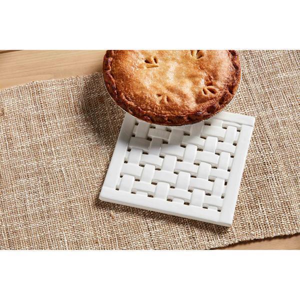 White woven coaster with a pie on a textured surface