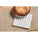 White woven coaster with a pie on a textured surface