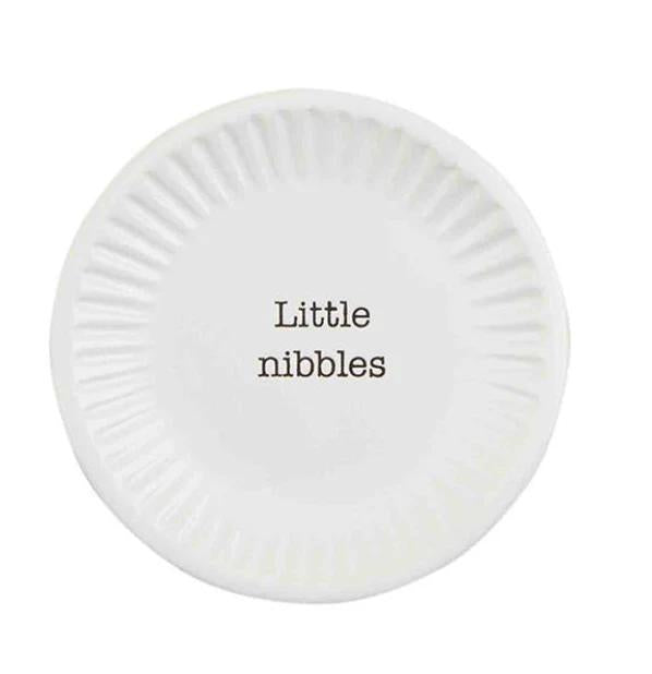 Round white plate with 'Little nibbles' text on a white background