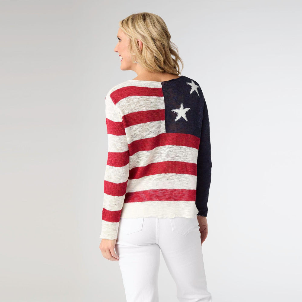 Person wearing a sweater with American flag design on a plain background