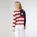 Person wearing a sweater with American flag design on a plain background