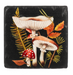 Decorative coaster with mushrooms and leaves on a black background