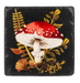 Decorative coaster with red and white mushroom design on a black background