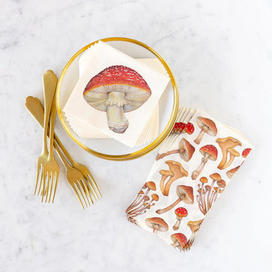 Mushroom-themed napkin on a marble surface with gold cutlery