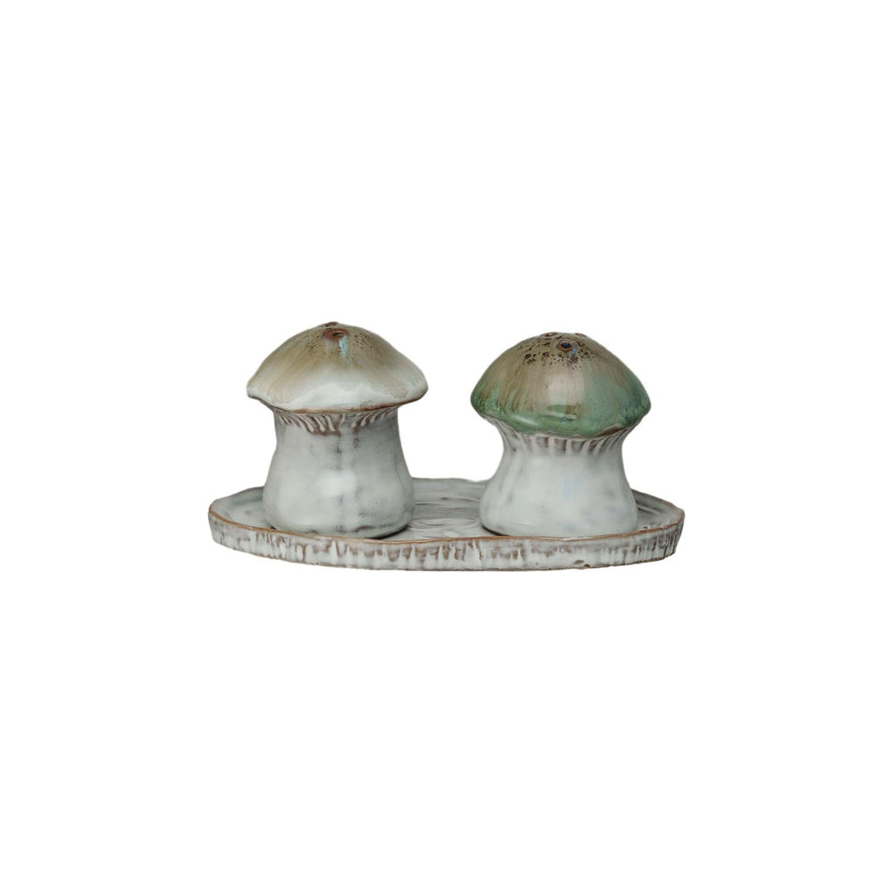 Mushroom-shaped salt and pepper shakers on a matching tray with a white background