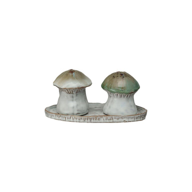 Mushroom-shaped salt and pepper shakers on a matching tray with a white background