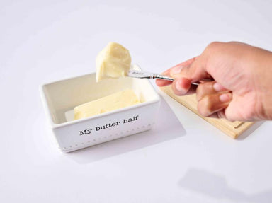 Person taking a scoop of butter from a container labeled 'My butter half' on a white background