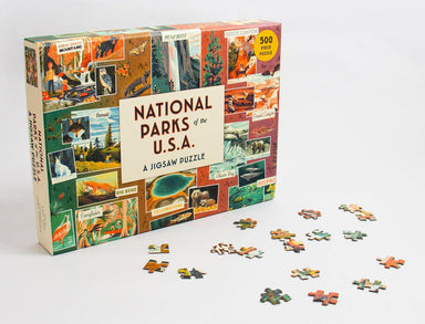 Jigsaw puzzle box for 'National Parks of the U.S.A.' with scattered pieces on a white background