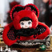 Plush toy with red hood and black accents on a decorative stand