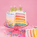 Colorful birthday cake with 'OLD AF' candles on a pink background