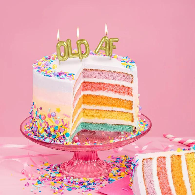 Colorful birthday cake with 'OLD AF' candles on a pink background
