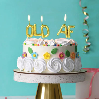 Birthday cake with 'OLD AF' candles on a turquoise background