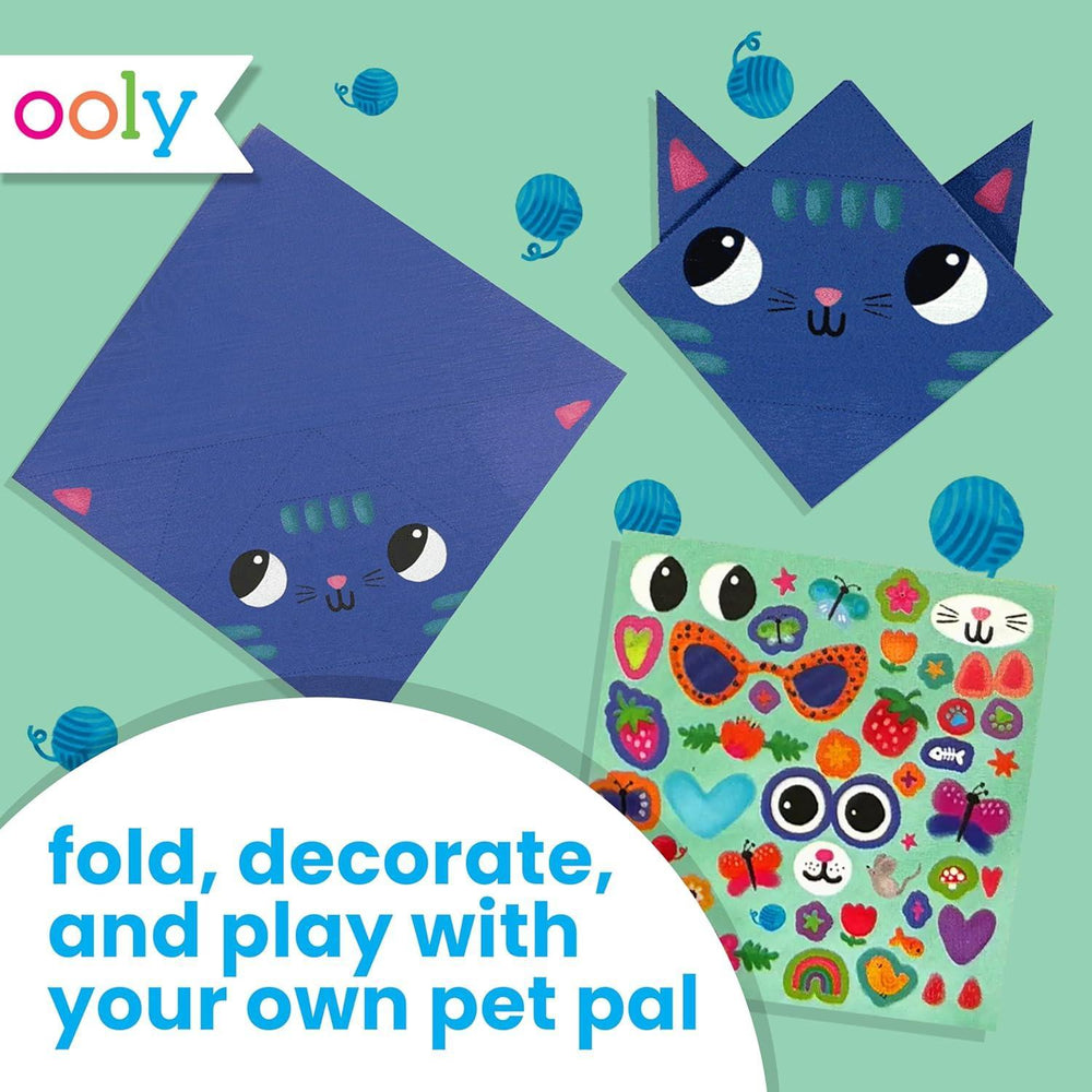 Cat-themed craft kit with colorful stickers on a green background, featuring the Ooly brand.