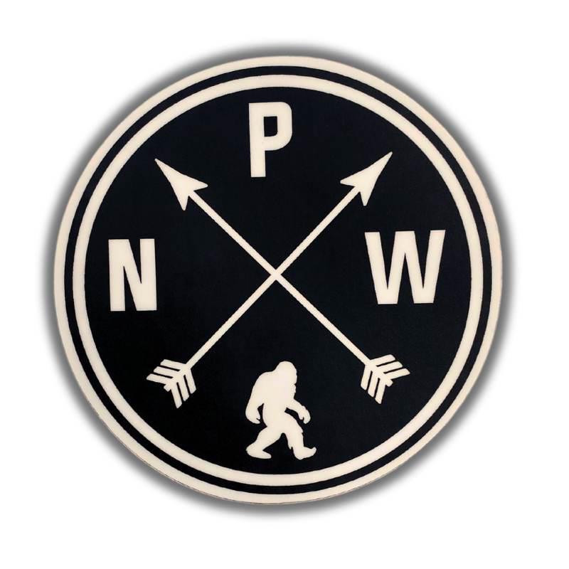 A circular black and off-white sticker or patch featuring the letters N, P, and W arranged around two crossed arrows and a small walking figure silhouette at the bottom, shown on a white background with a soft drop shadow.
