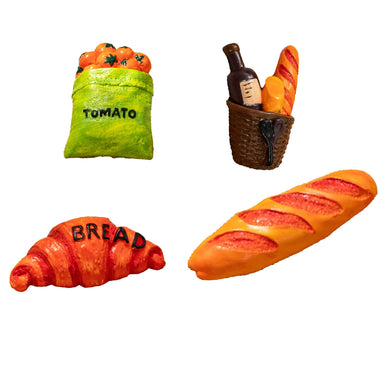 Set of toy food items including a bag of tomatoes, a bottle and bread in a basket, a croissant, and a loaf of bread on a white background.