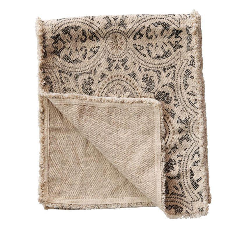 Patterned table runner with frayed edges on a white background