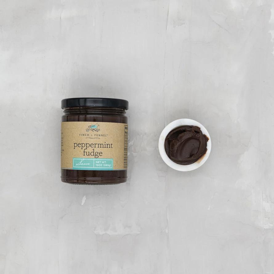 Jar of peppermint fudge with a small bowl of fudge on a gray surface