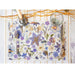 Floral placemat with cutlery on a white surface