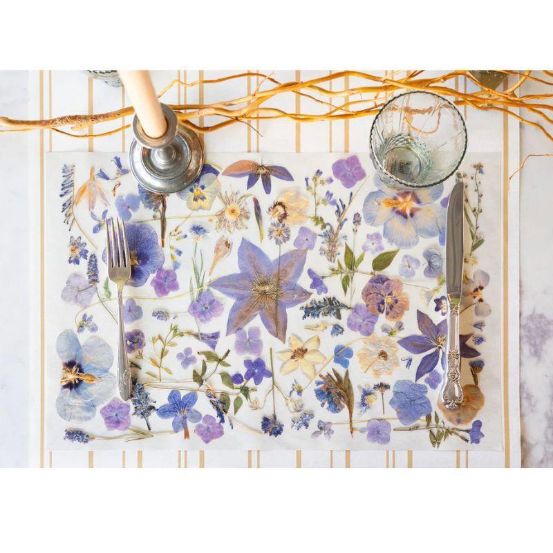 Floral placemat with cutlery on a white surface