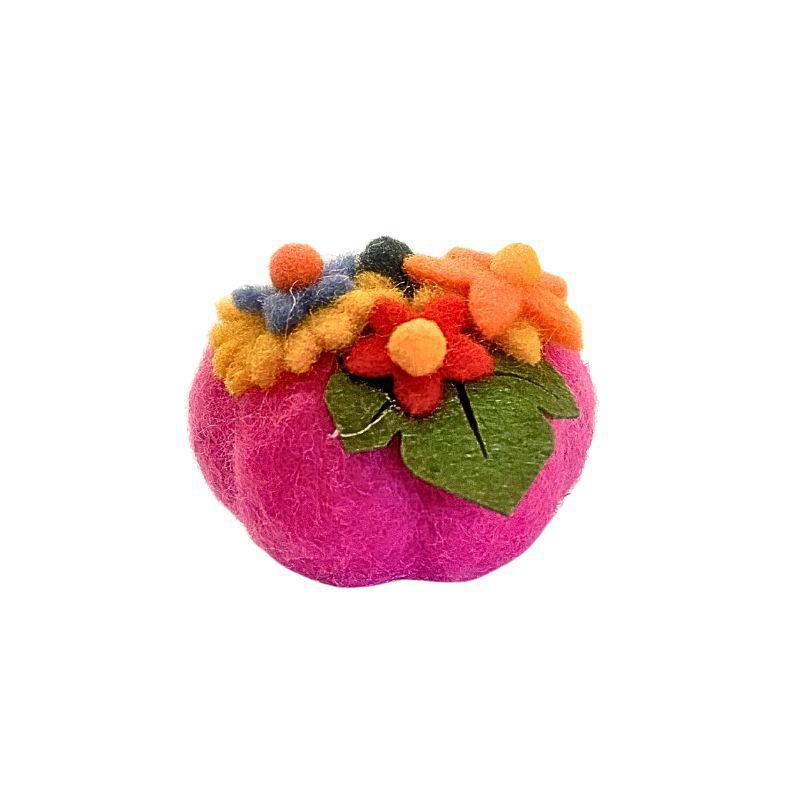 Pink felt pumpkin with colorful pom-pom flowers on a white background