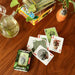 Playing cards with plant designs on a wooden table with card boxes in the background