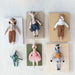 Set of handmade dolls displayed on wooden boards against a light background