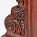 Close-up of a wooden chair with intricate carvings on a white background