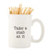 White mug with 'Take a stab at it' text and toothpicks on a white background