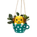 Hanging planter shaped like a dog in a polka dot teacup on a white background