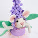 Stuffed mouse toy with a purple outfit and flower hat on a white background
