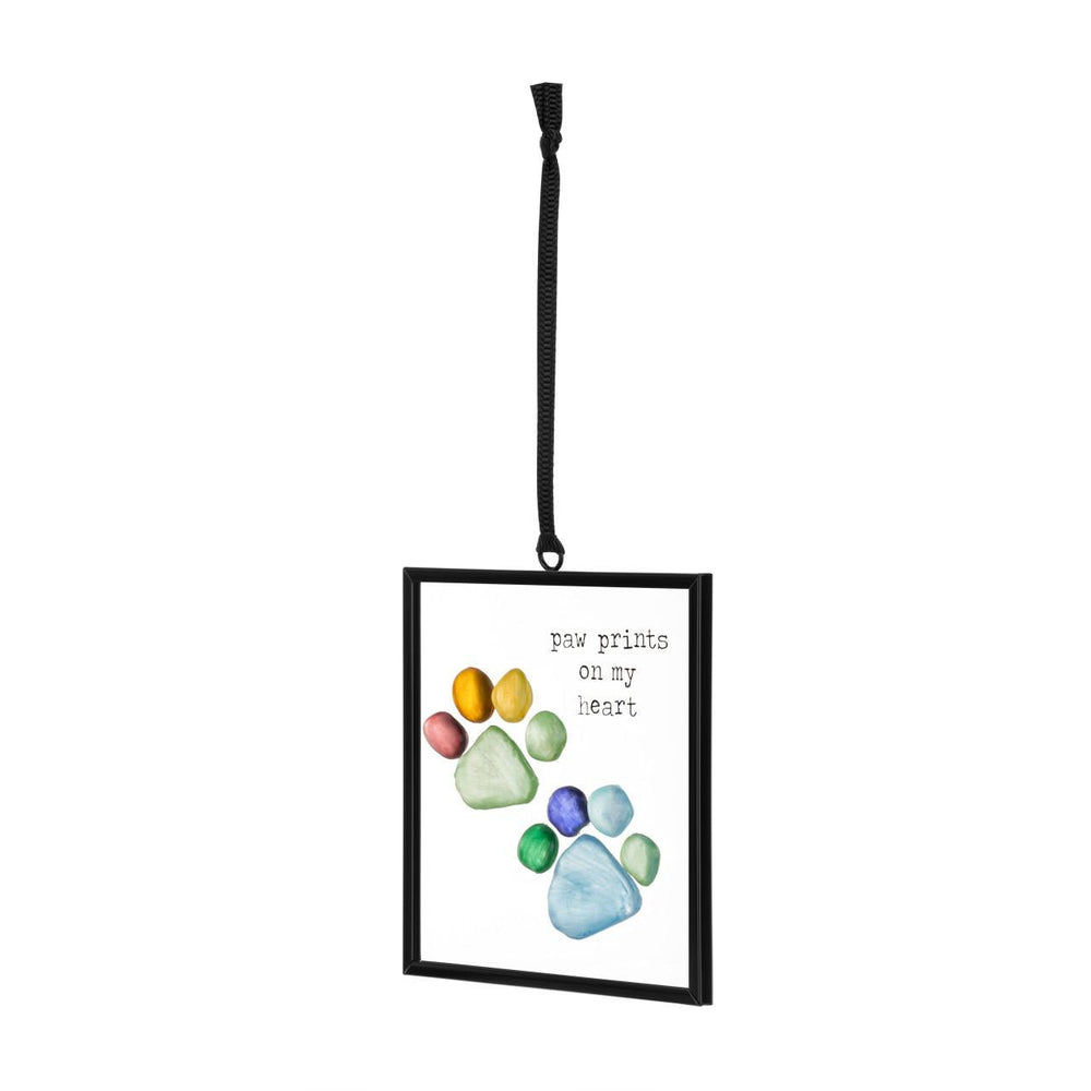 Decorative hanging frame with paw prints and text 'paw prints on my heart' on a white background