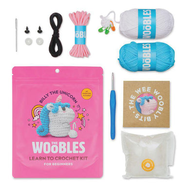 Crochet kit with yarn, hooks, and a pink 'The Wobbles' package on a white background