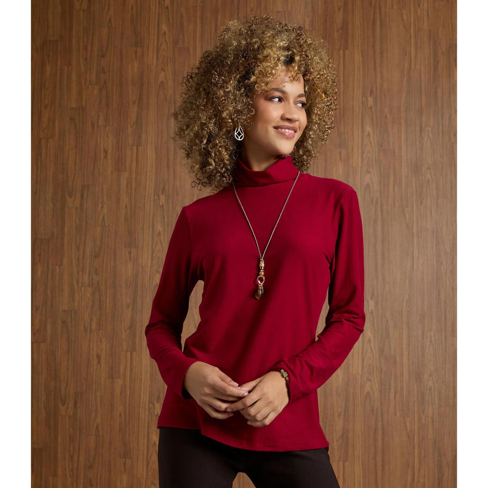 Woman wearing a red turtleneck sweater against a wooden background