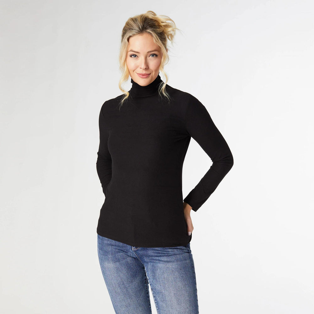 Woman wearing a black turtleneck sweater and blue jeans on a white background