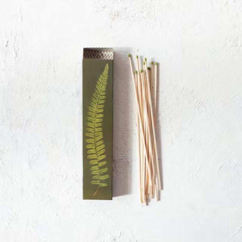 Reed diffuser with packaging featuring a fern design on a white background