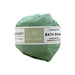 Green bath bomb wrapped in paper with a label on a white background