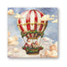 Christmas-themed hot air balloon with Santa Claus and reindeer in a basket, surrounded by clouds.