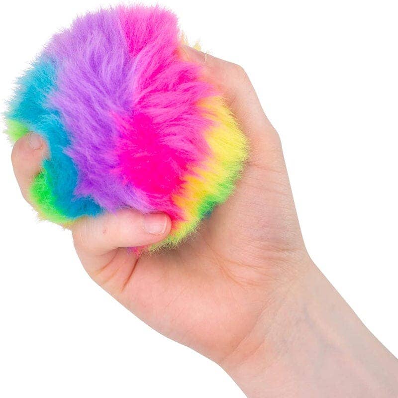 Hand holding a multicolored fluffy ball against a white background