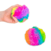 Colorful fluffy ball held in a hand with another ball on a white background