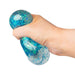 A hand squeezing a blue glittery stress ball against a plain white background.
