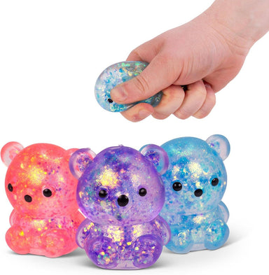 Colorful glittery bear-shaped fidget toys with a hand squeezing one of them.