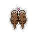 A die-cut sticker featuring two cute cartoon brown otters facing each other with a small pink heart above them, shown on a plain white background.