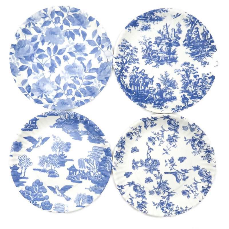Set of four blue and white patterned melamine plates on a white background